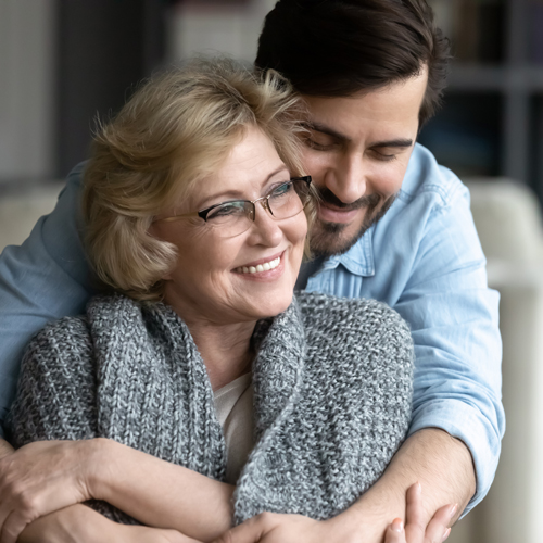 Adult son hugging his mother both smiling