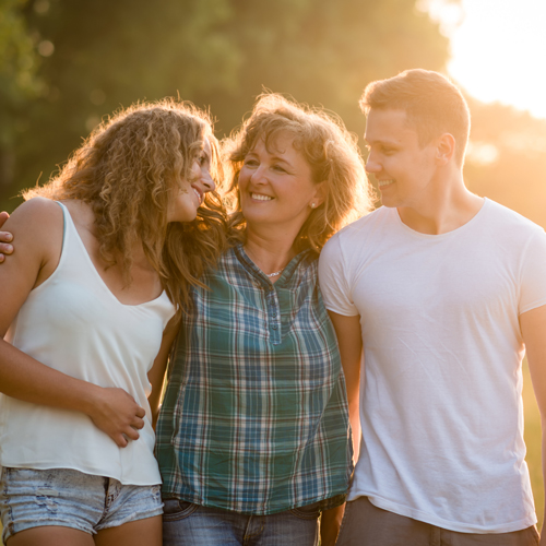 Mother with her two adult children all smiling.