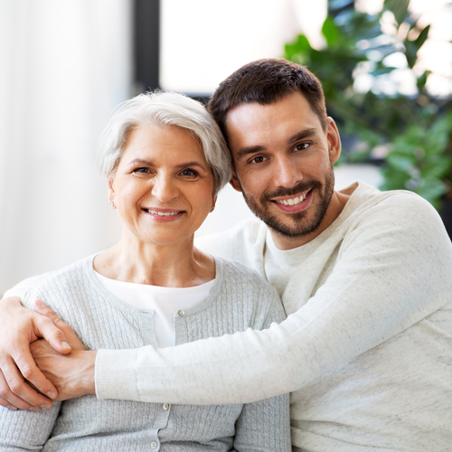 Happy older woman and adult son hugging