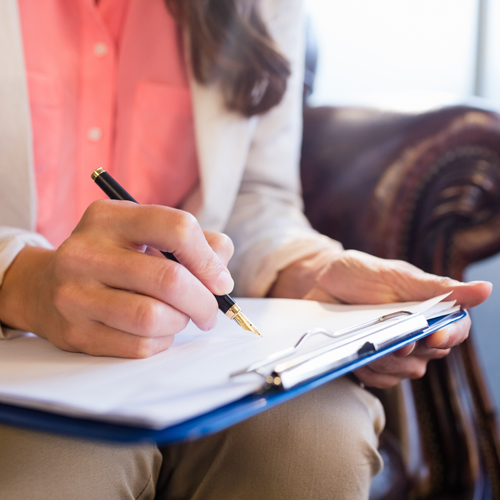 Counselor taking notes during therapy session