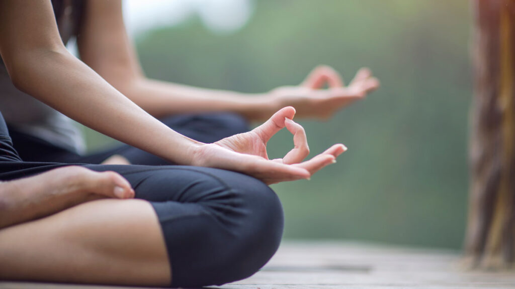 2 women on a dock doing yoga